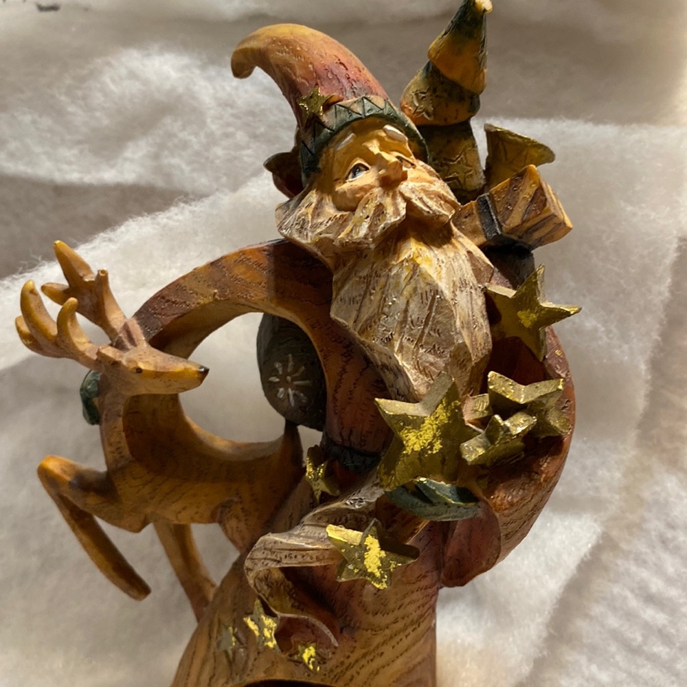 Santa with arms full of stars and a reindeer. Resin piece that looks like wood.